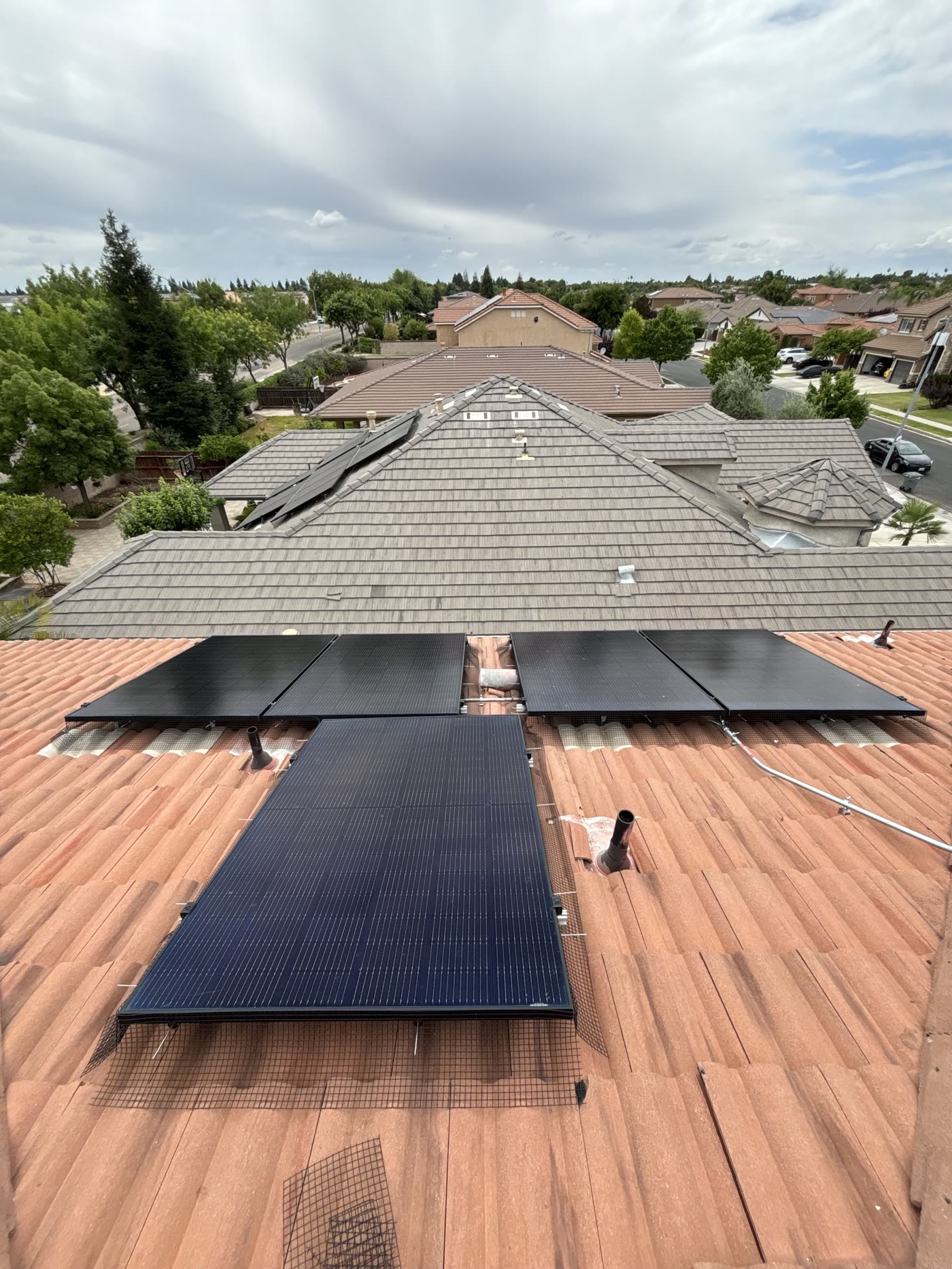 The same solar array after cleaning and bird proofing, with clean tile beneath the panels and the perimeter closed off